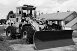 Close-up of a bulldozer's blade with Panama port in background.