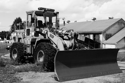 Close-up of a bulldozer's blade with Panama port in background.