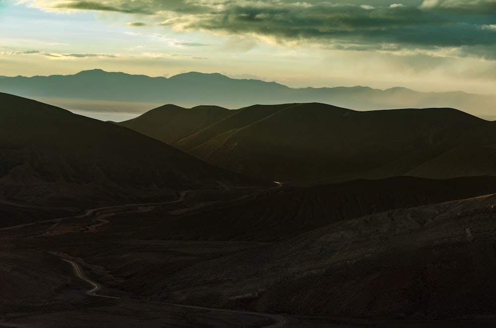 Panoramafotografie einer Graswiese in der Nähe einer Bergkette unter Cumuluswolken