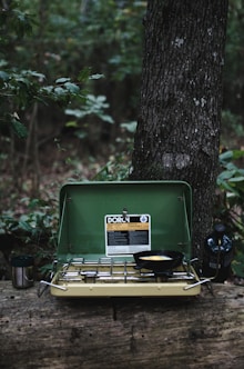 selective focus photography of camping stove on lug with cooked egg on pan