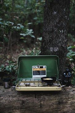 selective focus photography of camping stove on lug with cooked egg on pan