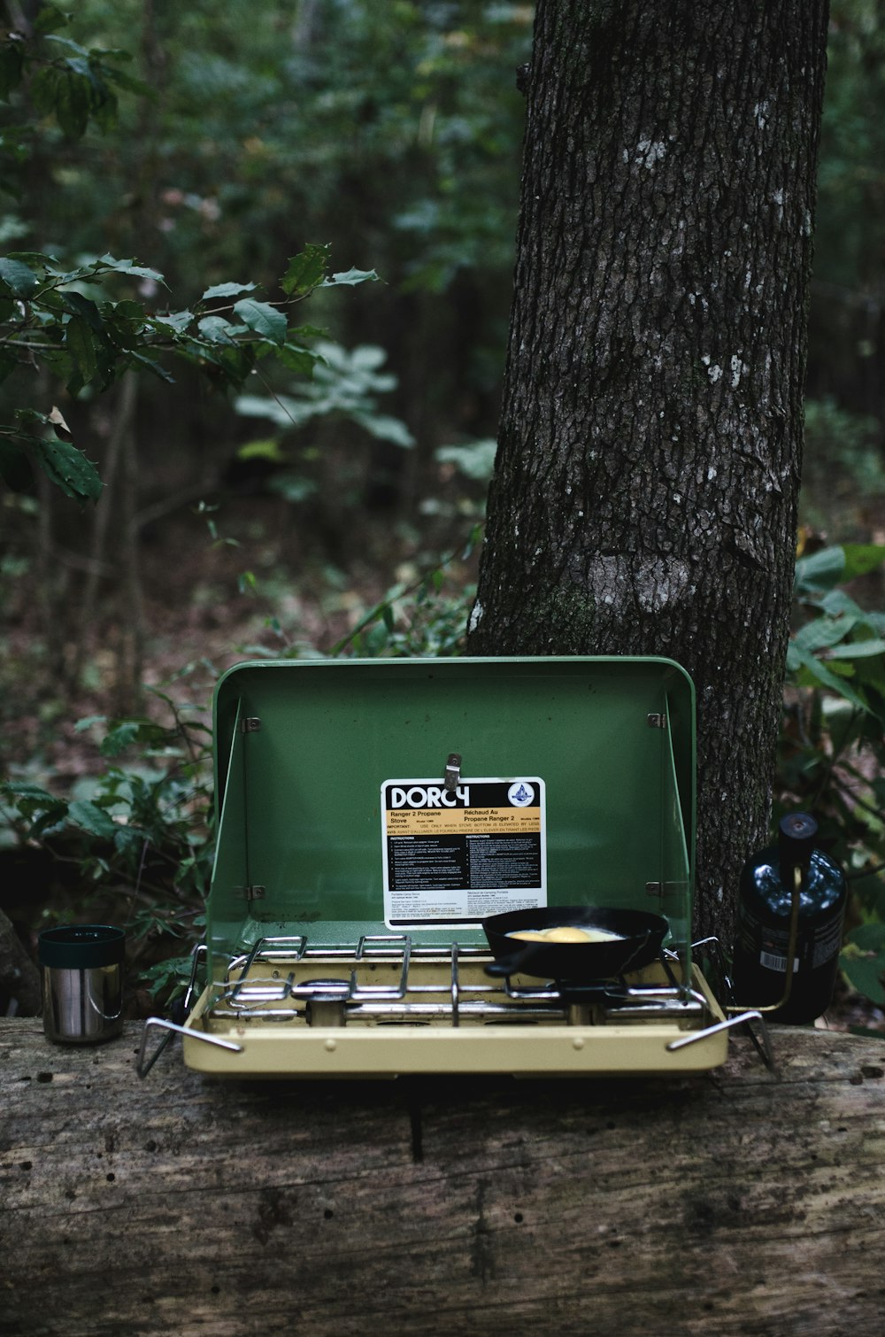 Photographie sélective de mise au point du réchaud de camping sur la patte avec un œuf cuit sur la poêle