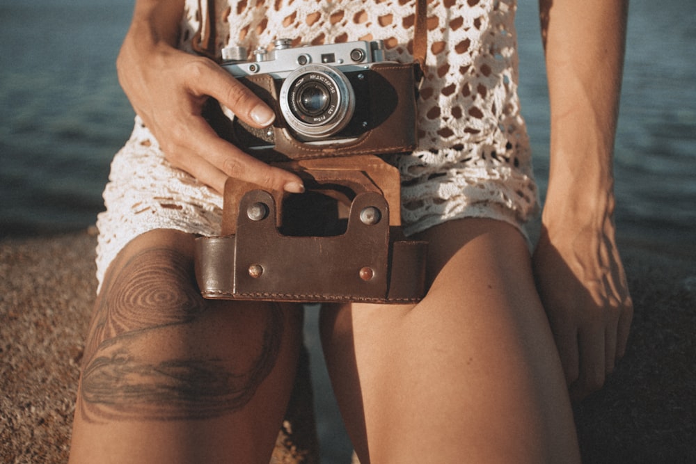 person holding camera near water