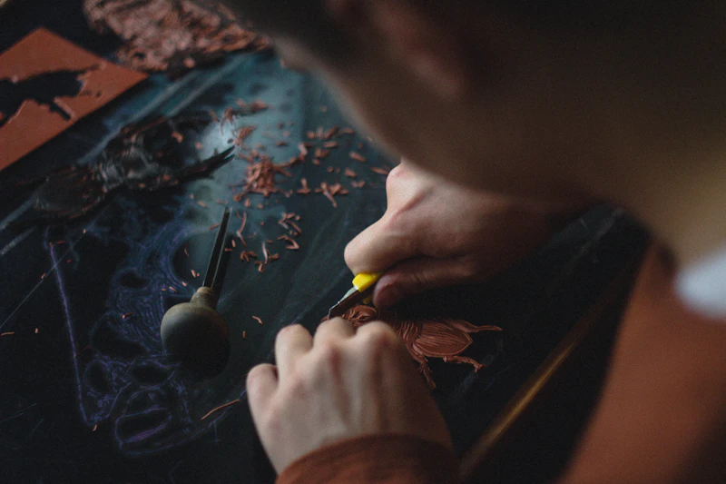 Hands carving dark wood