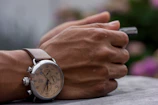 Close-up of hands holding a smartwatch designed for elderly users.