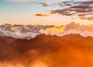 landscape photography of mountains with cloudy skies during golden hour