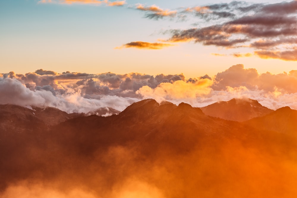 Landschaftsfotografie von Bergen mit bewölktem Himmel während der goldenen Stunde