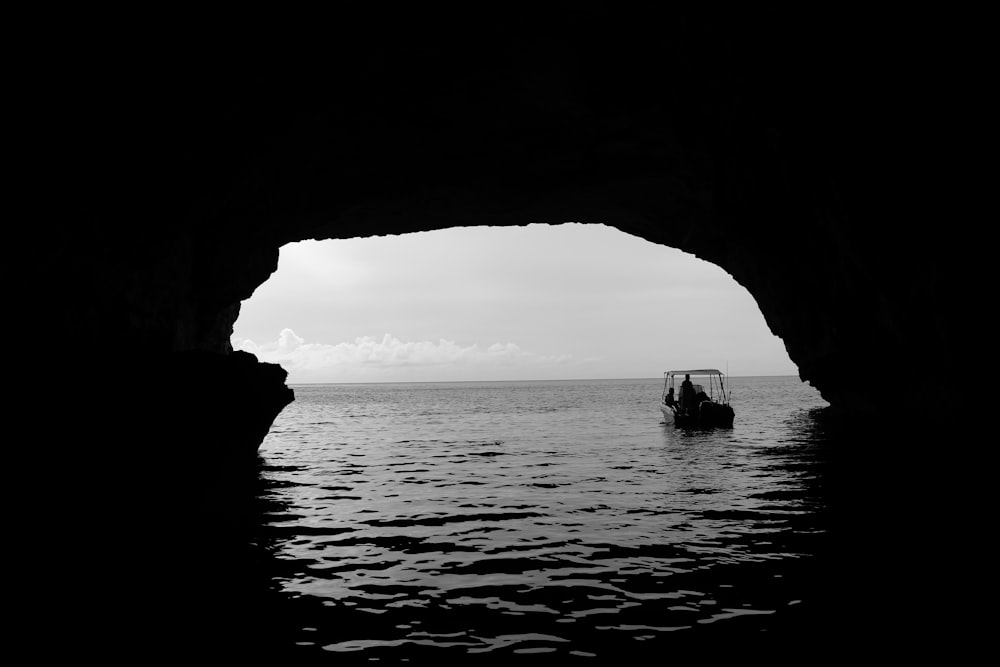 boat on body of water outside the cave