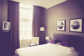 Bedroom of the second housing unit with a large window and soft lighting