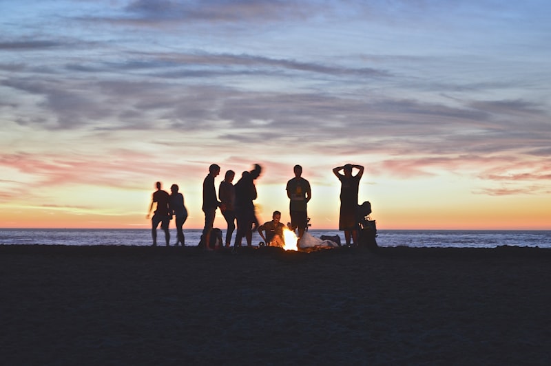 People having a bonfire on the beach at sunset