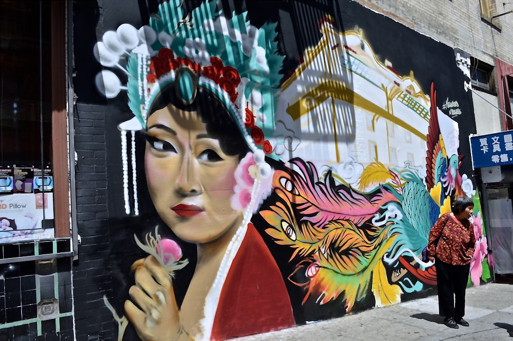 Uma mulher asiática segurando uma flor, pintada em uma parede.