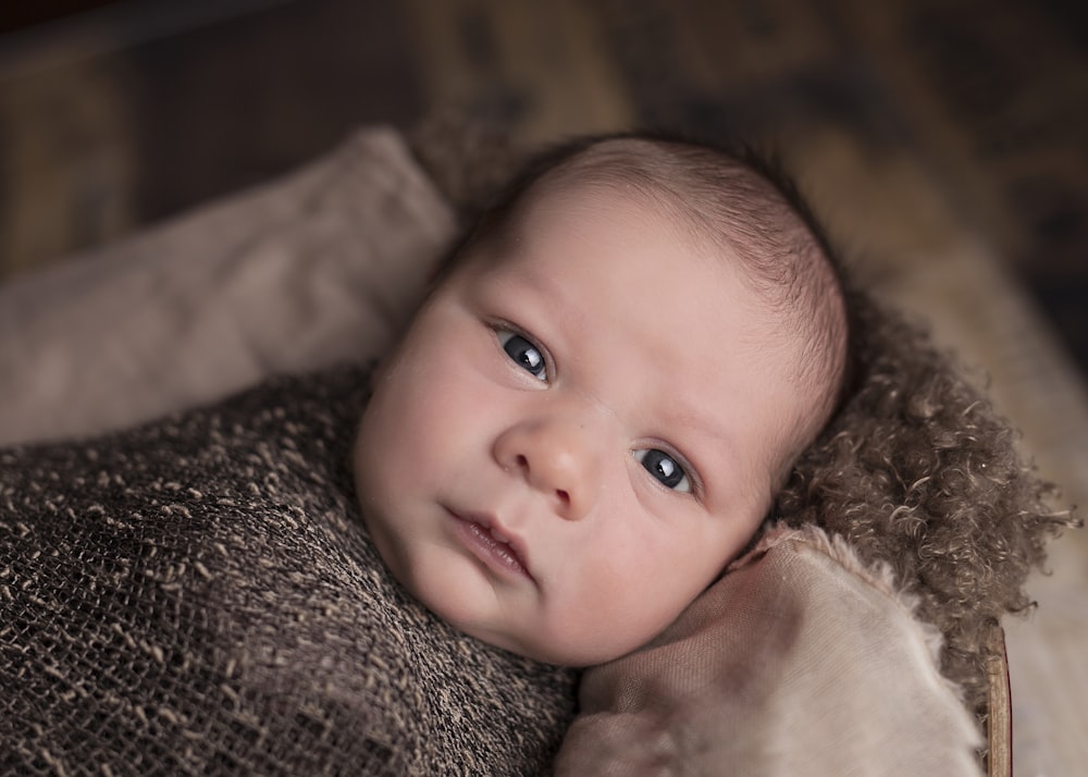 baby in brown swaddle
