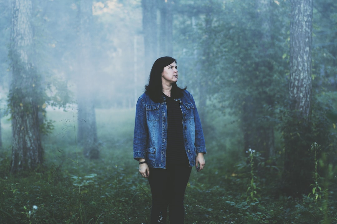 woman standing surrounded with trees