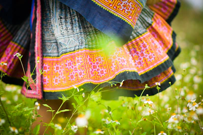 A colorful skirt flowing in the breeze, photographed outdoors with greenery in the background.
