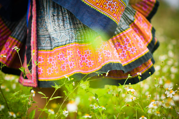 Close-up of a vibrant skirt with intricate patterns, displayed on a rustic wooden table.
