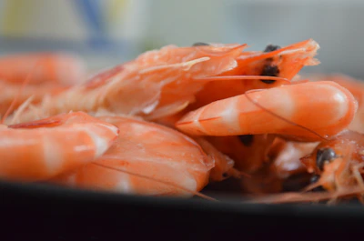 Close-up of succulent prawns with a hint of seaweed, showcasing their bright orange color and freshness.