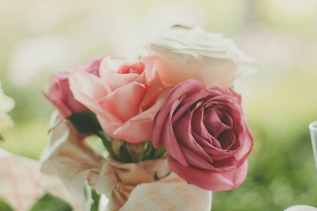 Close-up of delicate blush pink floral arrangement with soft watercolor background.