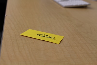 A handwritten note with a heart, placed on a wooden desk.