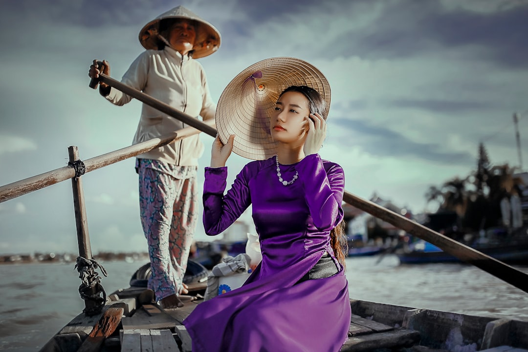 woman riding on boat rowed by standing woman