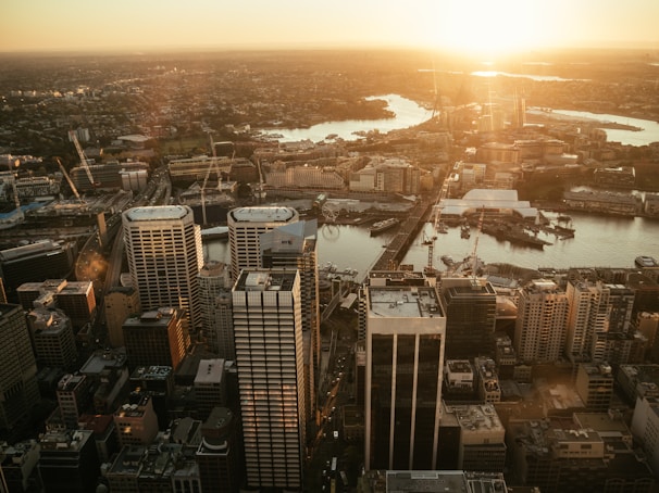A sweeping aerial shot of a cityscape bathed in golden hour light