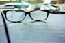 black-framed eyeglasses on white printing paper