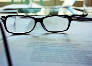 black-framed eyeglasses on white printing paper