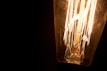 Close-up of a unique filament bulb glowing warmly inside a vintage baseball glove.