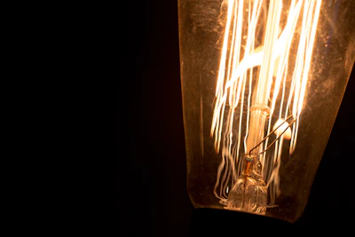 Close-up of a glowing vintage tube preamp with warm amber light against a dark blue backdrop.
