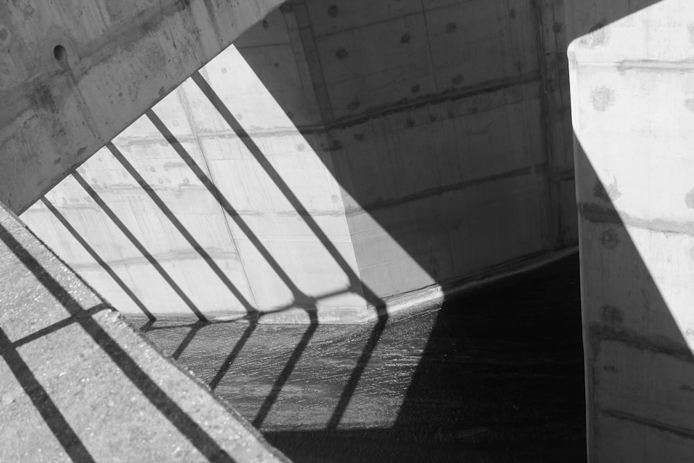 photographie minimaliste de mur gris avec des ombres de gril