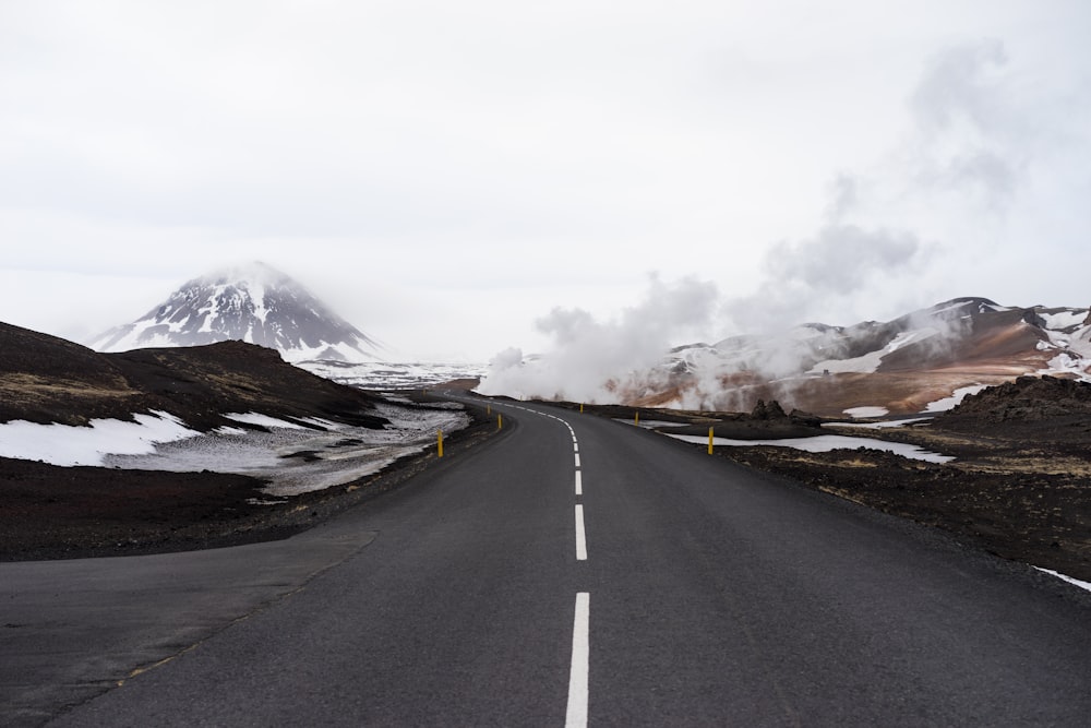 concrete road with snow-capped mountain at distance