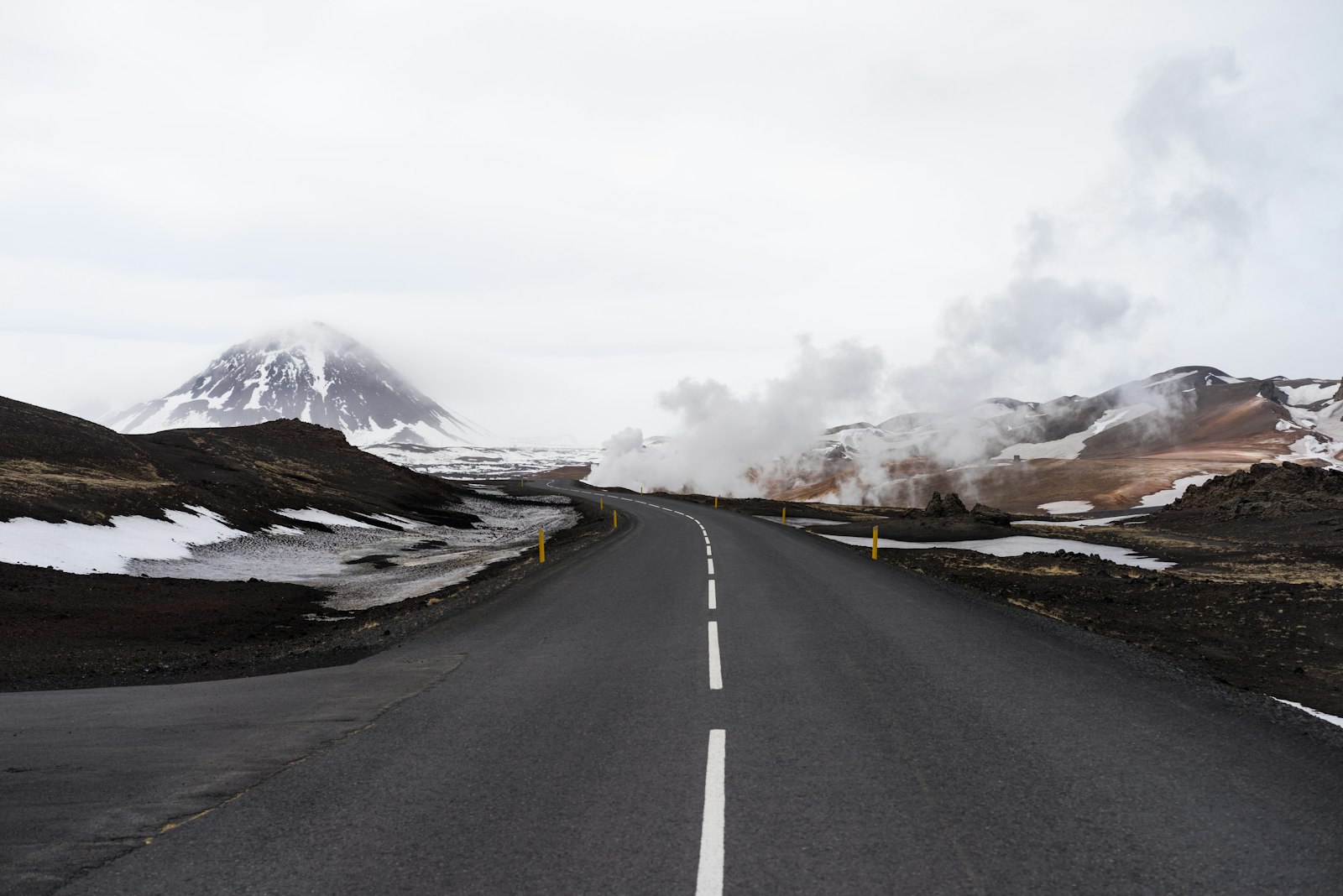 Sony a7R + Sony Sonnar T* FE 55mm F1.8 ZA sample photo. Concrete road with snow-capped photography