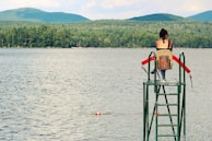 women sitting on chair watching body of water