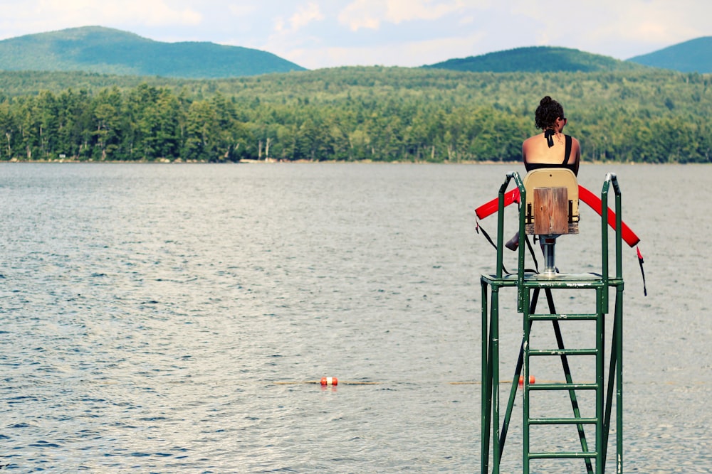 femmes assises sur une chaise regardant le plan d’eau