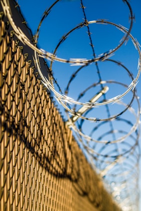 an electric security fence with barbed wire