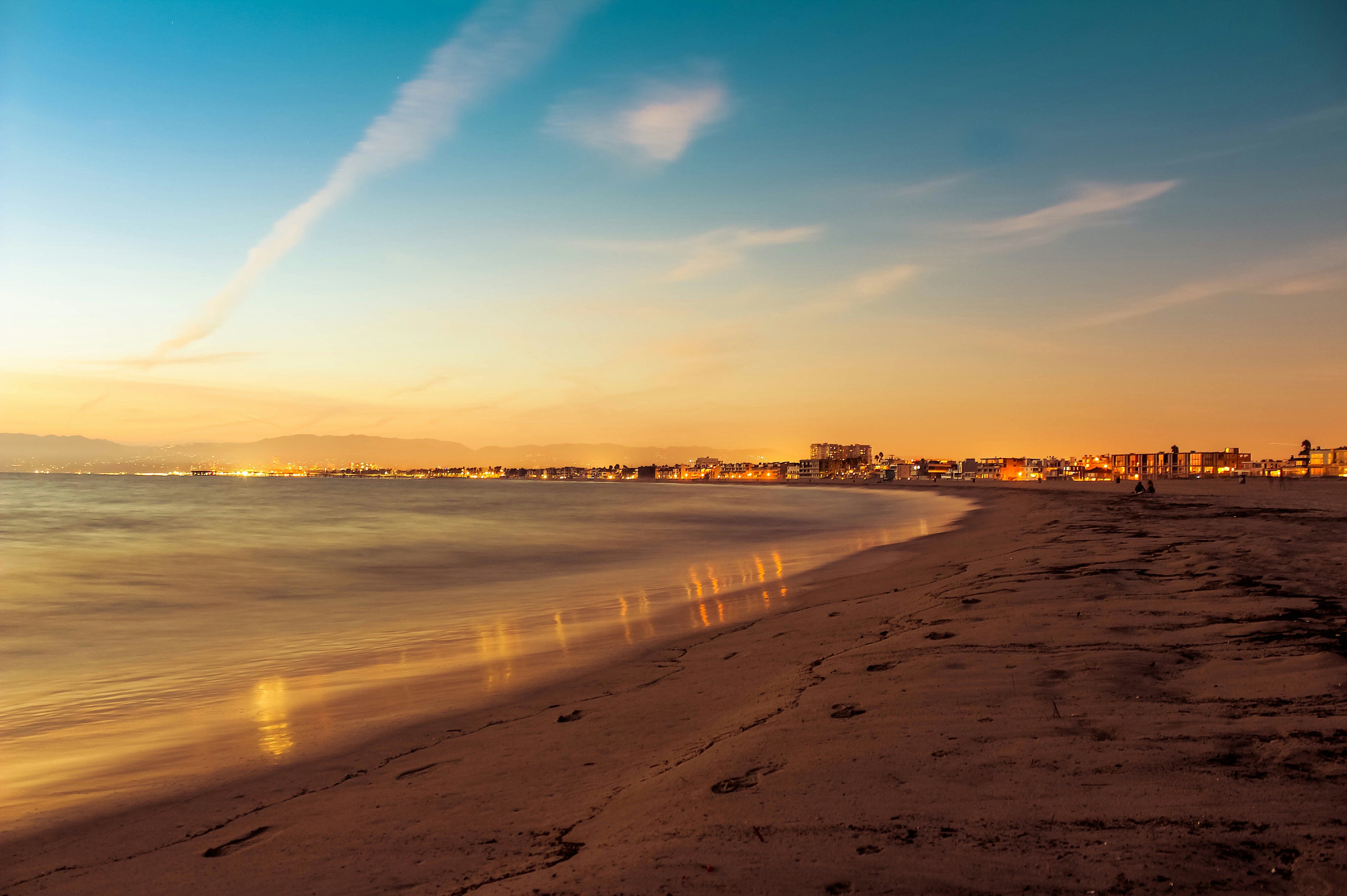 Venice beach comes alive as the ocean and shore are lit up by the sunset