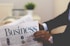 person wearing suit reading business newspaper