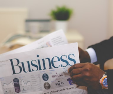 person wearing suit reading business newspaper