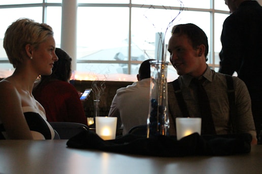 A couple enjoying a romantic dinner with candles and soft lighting.