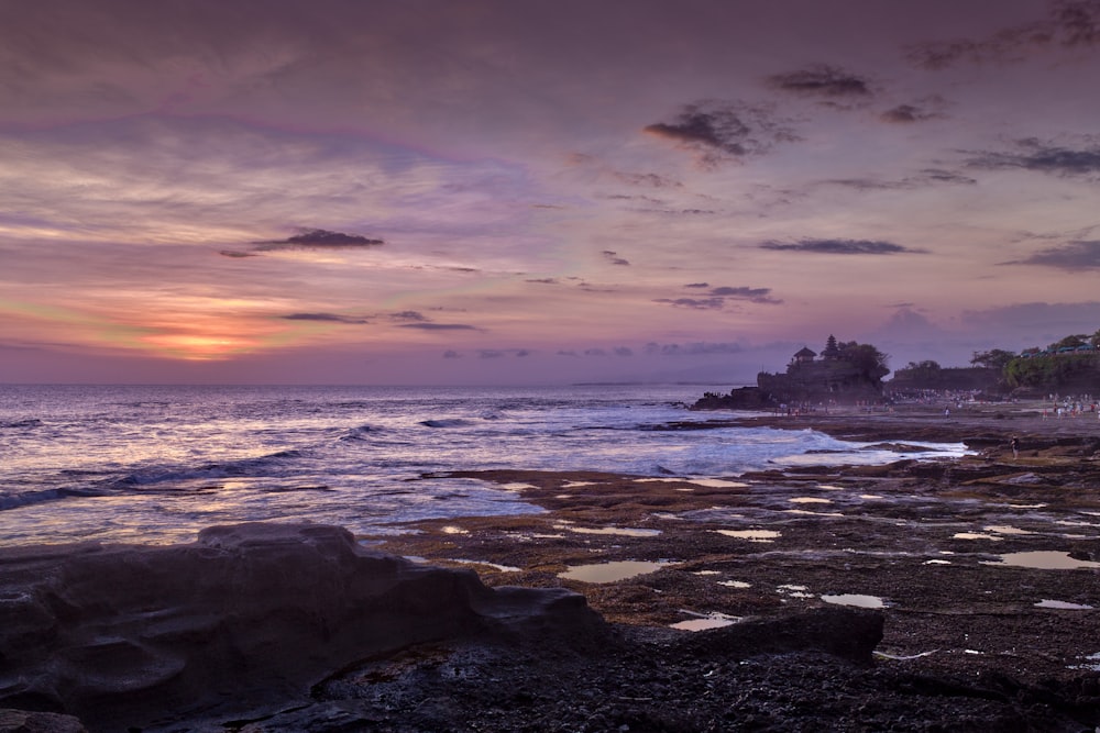 blue sea hitting seashore during golden hour