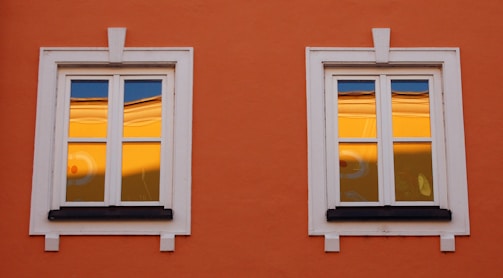Bright white window frames and amber door on a freshly remodeled house.