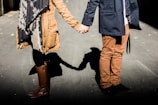 man and woman standing while holding hands at daytime