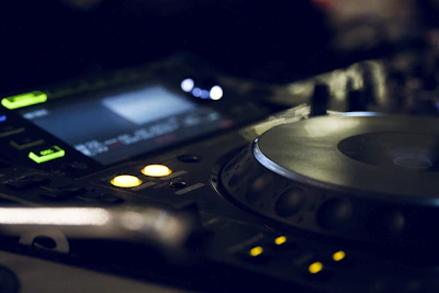 Close-up of DJ Julestonic mixing tracks on a modern console under moody lighting.