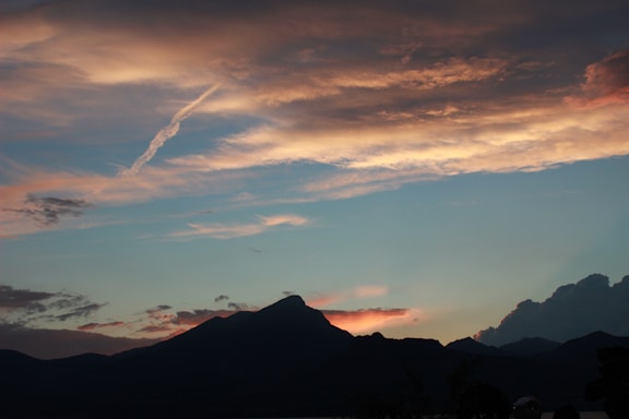 A serene landscape featuring mountains and a tranquil sky at sunset.
