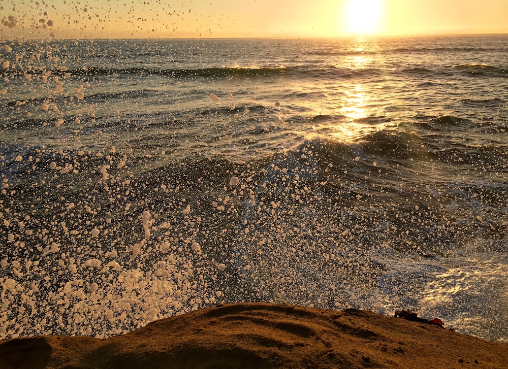 Photographie en accéléré de l’éclaboussure de vague de mer pendant l’heure d’or