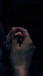 A warm moment showing a caregiver gently holding hands with a chronically disabled person in a sunlit room.