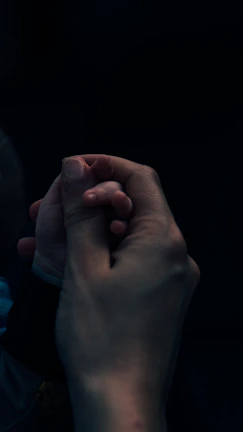A close-up of hands gently touching, symbolizing connection and tenderness.