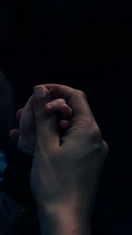 Close-up of hands gently holding a partner’s hand, reflecting trust and connection.