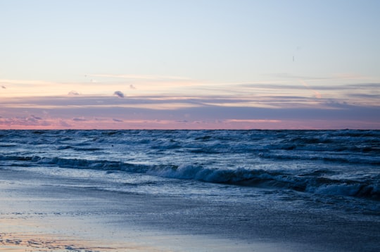 close up photo of ocean waves hitting shore in Karwia Poland