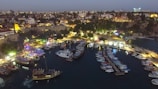 Panoramic view of Dubai Marina at dusk with boats and city lights.