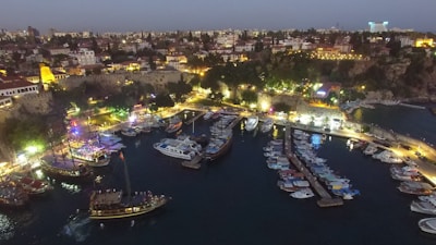 Panoramic view of Dubai Marina at dusk with boats and city lights.
